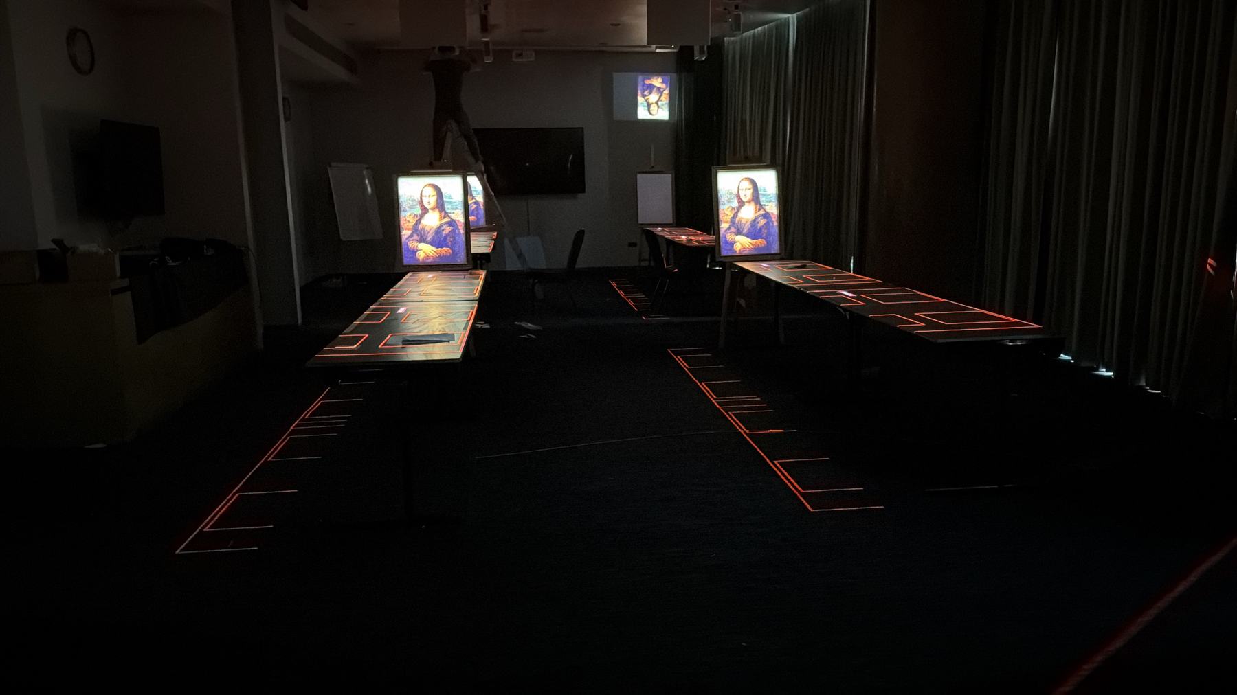 Amber frames projected onto tables and floor during setup