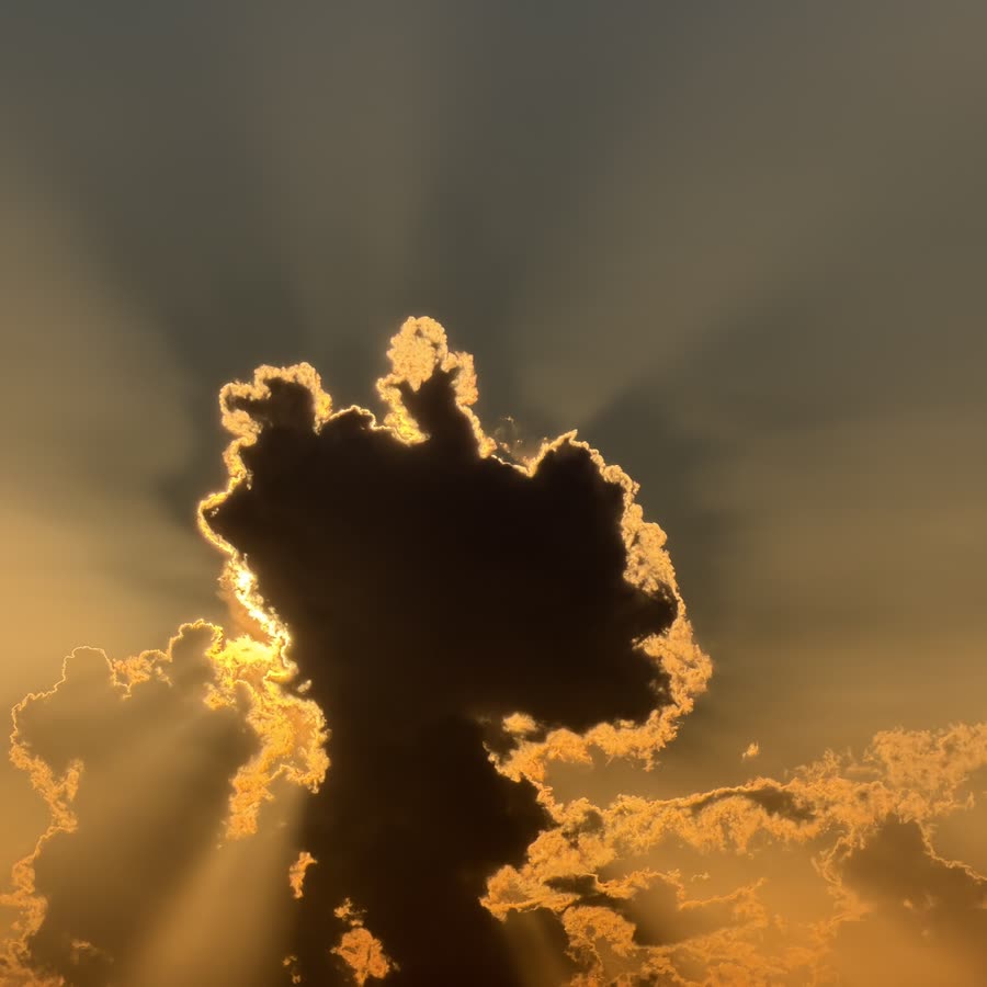 A dark cloud with a glowing golden edge, the sun breaking through behind it